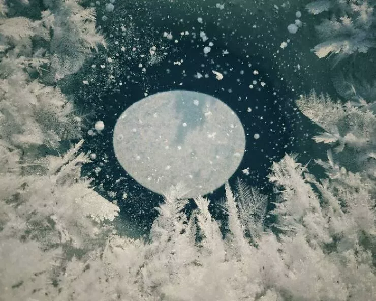 Doubles regards enchants des moments qui exigent un deuxime coup doeil - #2 Cette bulle dans un trou de pêche sur glace qui a gelé ressemble à la lune se levant au-dessus d'une forêt